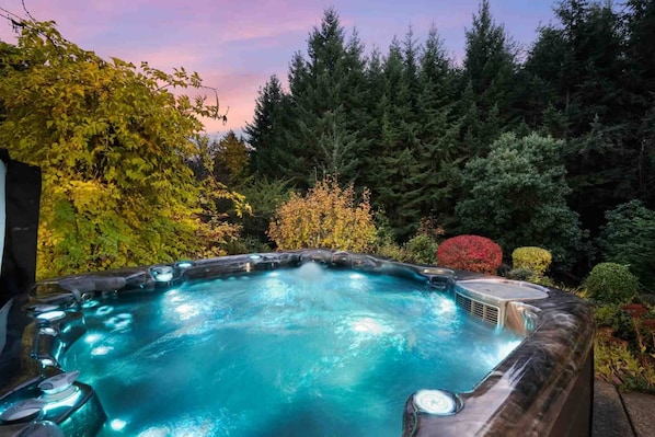 A hot tub surrounded by lush greenery and trees.