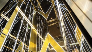A modern interior with geometric metal structures and reflective surfaces. - Alion Hotel (Izmir)