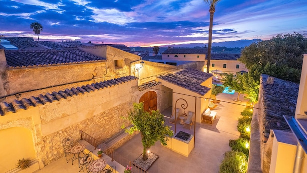 Un patio con piscina, mobiliario exterior y vistas de los edificios circundantes.