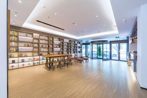 Een moderne bibliotheek met boekenkasten, een houten tafel en een glazen ingang.