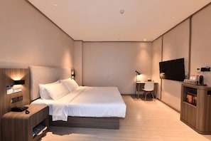 A modern hotel room with a bed, bedside table, TV, and a small desk with a chair. - Wanting Hotel (Zhengzhou Zhenghonghui Yinping Road Subway Station) (Zhengzhou)
