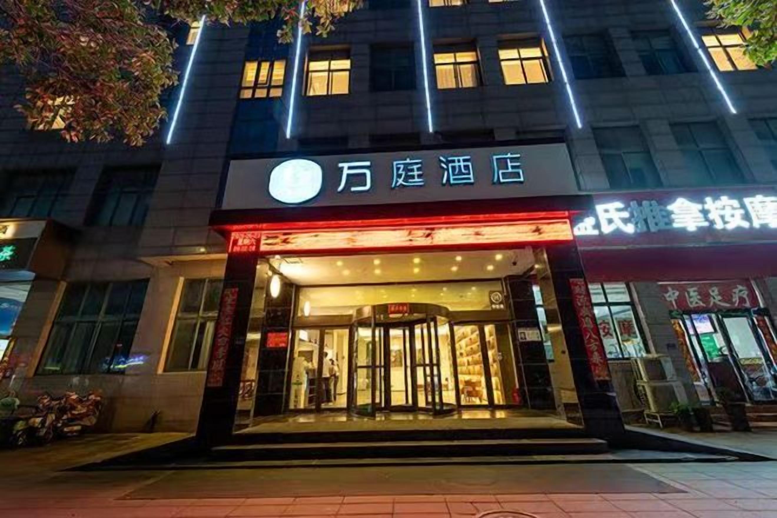 A hotel entrance with a prominent sign, a glass door, and a visible entrance area.