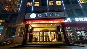 A hotel entrance with a prominent sign, a glass door, and a visible entrance area.