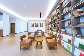 A modern library with bookshelves, seating, and a wooden floor. - Wanting Hotel (Zhengzhou Zhenghonghui Yinping Road Subway Station) (Zhengzhou)