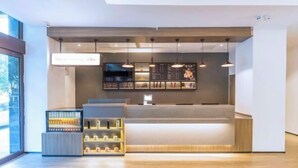 Interior moderno de una cafetería, con mostrador, lámparas colgantes y una pizarra de menú.
