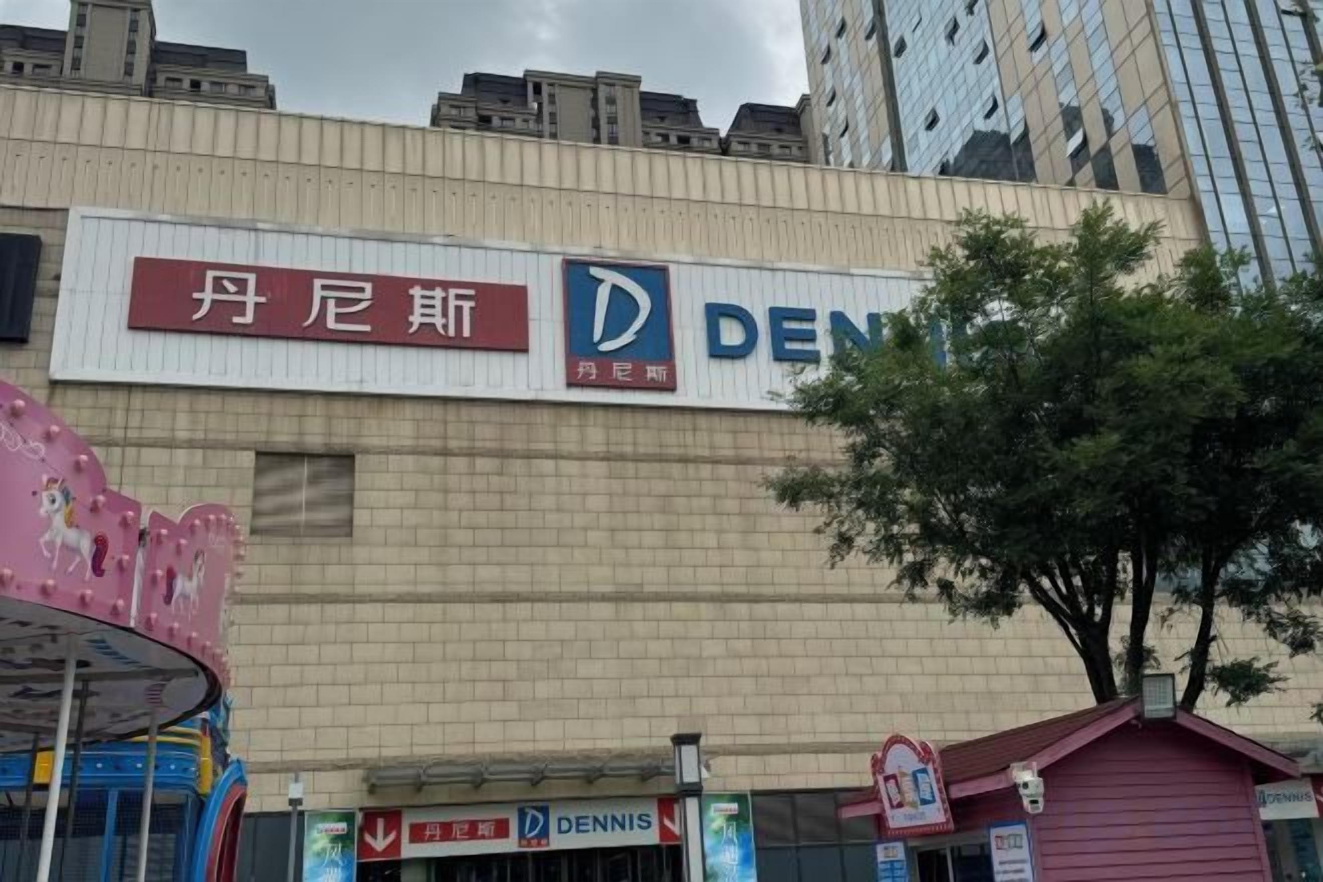 A building with a sign for 'DENNIS' and a smaller sign for '丹尼斯' in a foreign language.