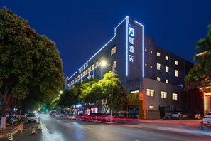 Un hôtel doté d’une enseigne verticale bien visible, de nombreuses fenêtres et d’une façade moderne.