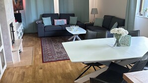 Una sala moderna con un sofá, una mesa de comedor y un televisor.