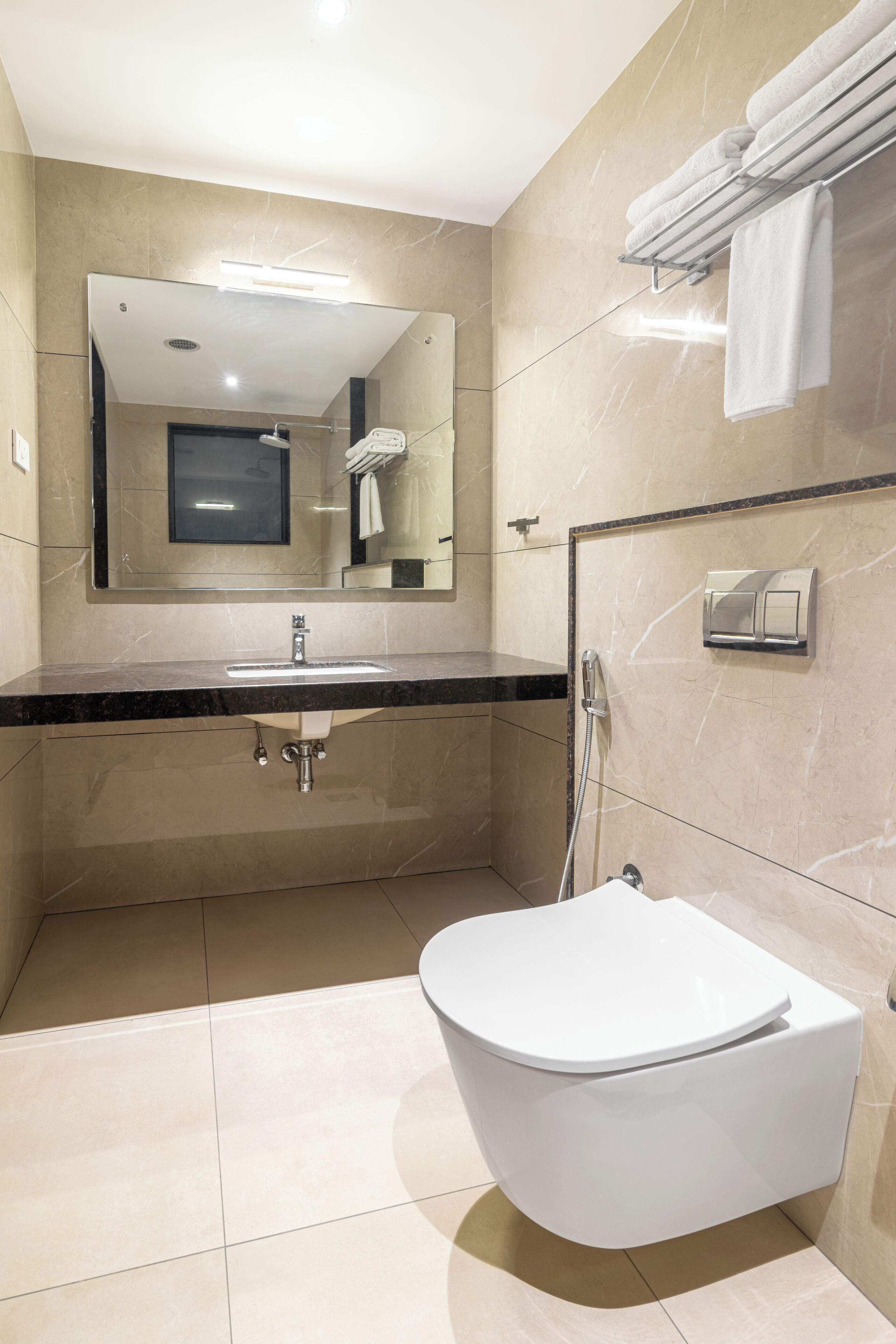 Un baño moderno con tocador, lavamanos, espejo y un inodoro independiente.