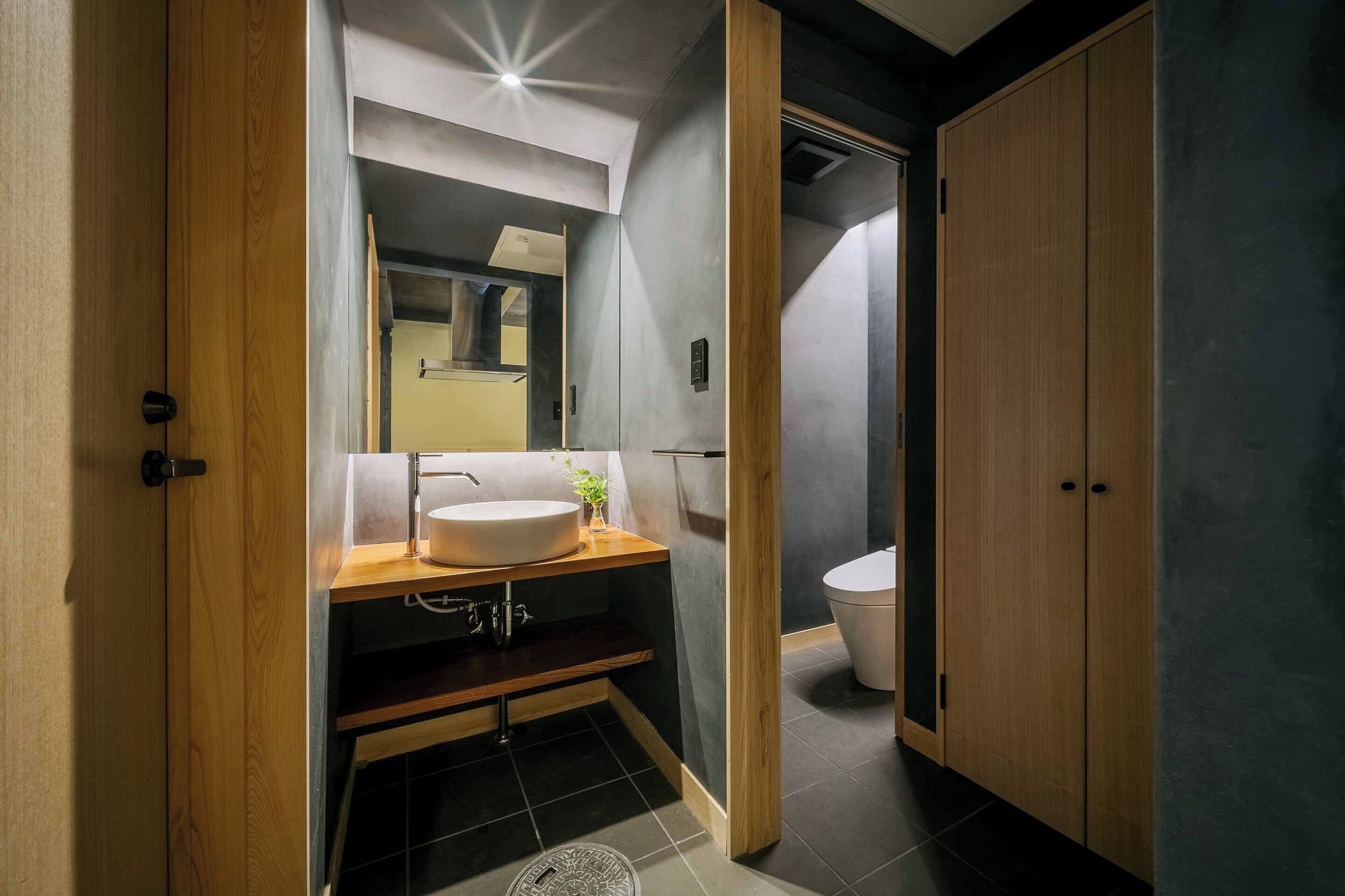 Un bagno moderno con un mobile bagno in legno, un lavello e un water.