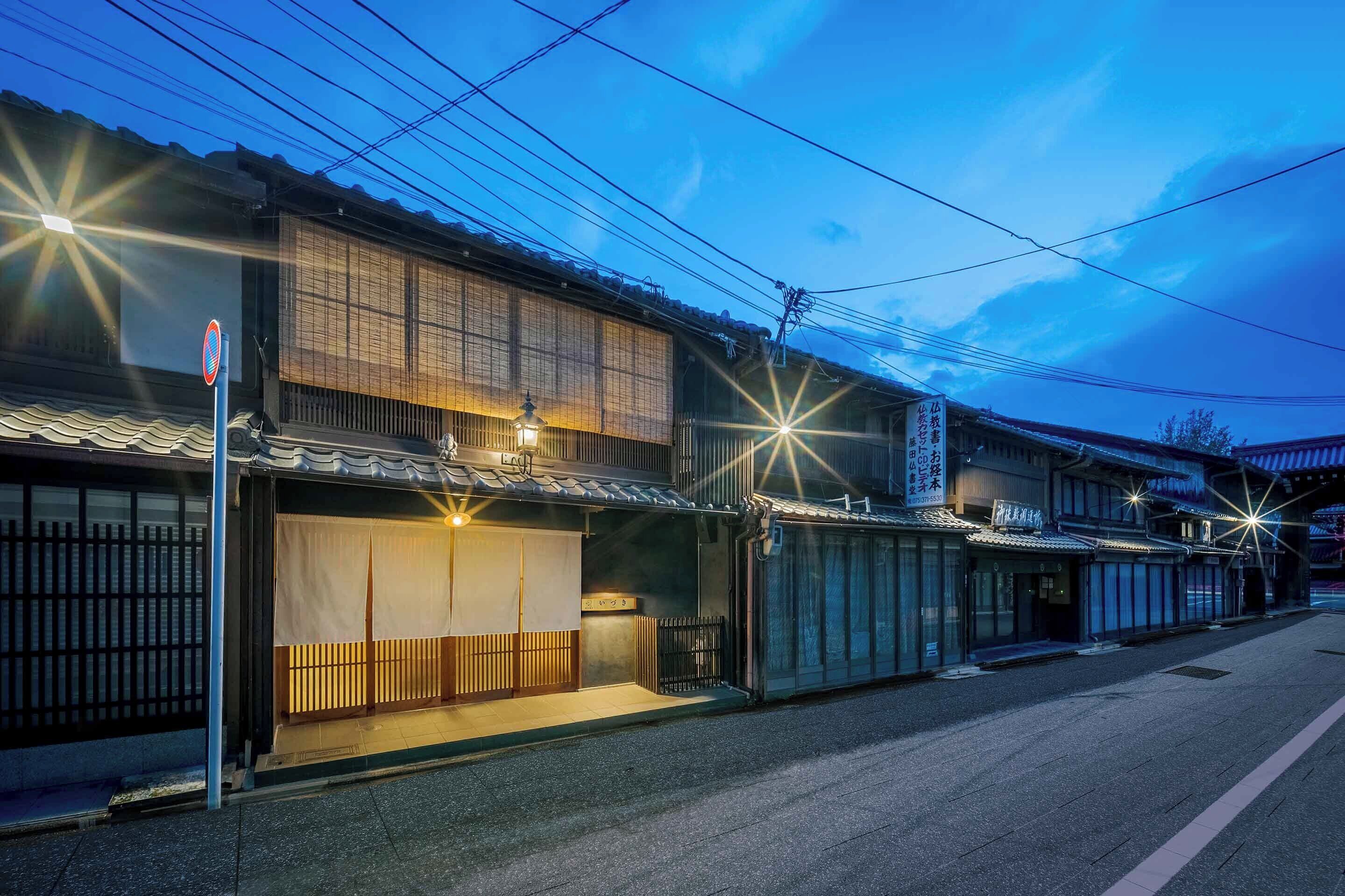 Un edificio japonés tradicional con un porche cubierto, un letrero y una farola.