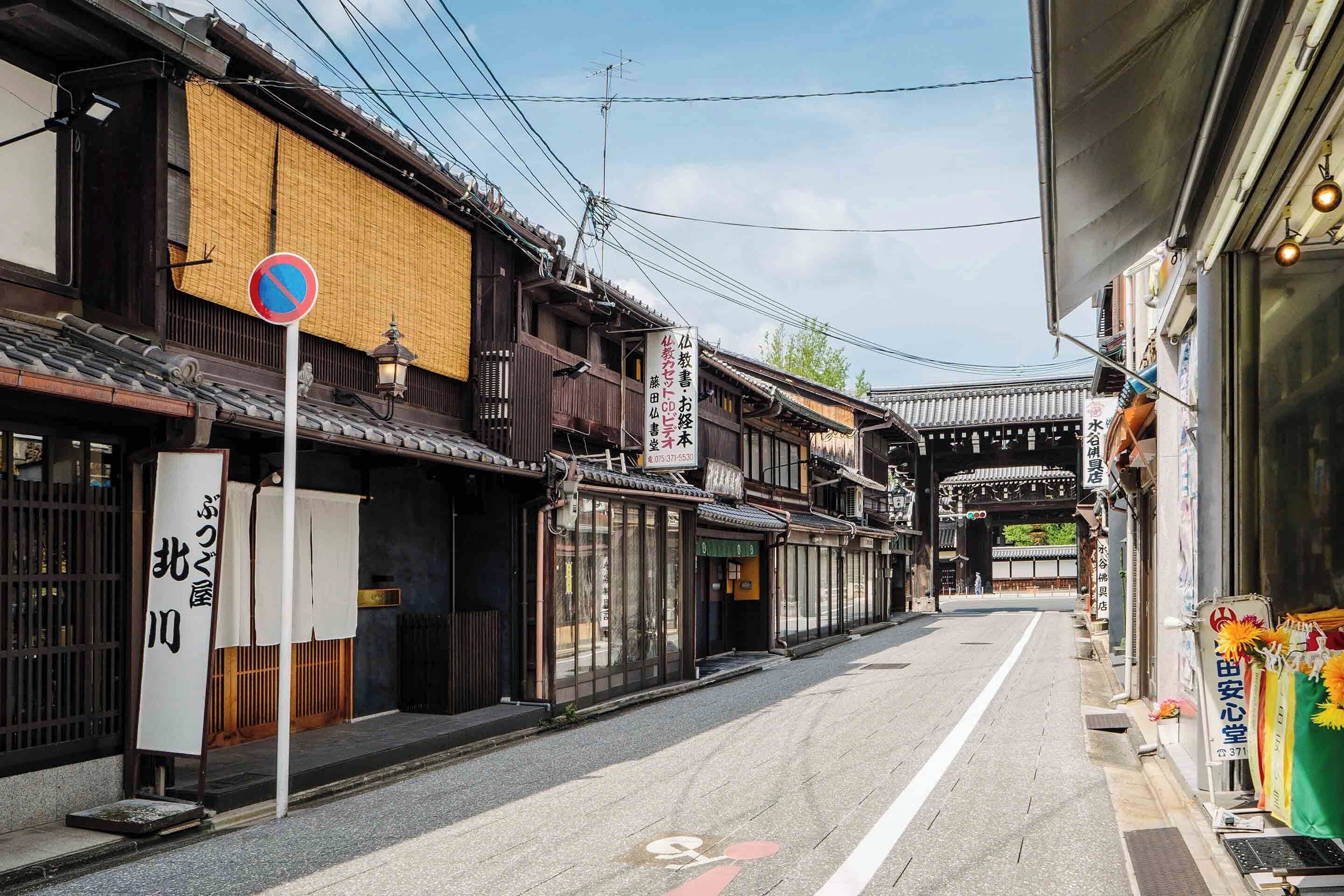 A traditional Japanese street with wooden buildings, a no parking sign, and a clear path for pedestrians.