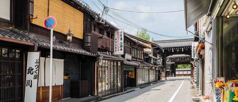 A traditional Japanese street with wooden buildings, a no parking sign, and a clear path for pedestrians.