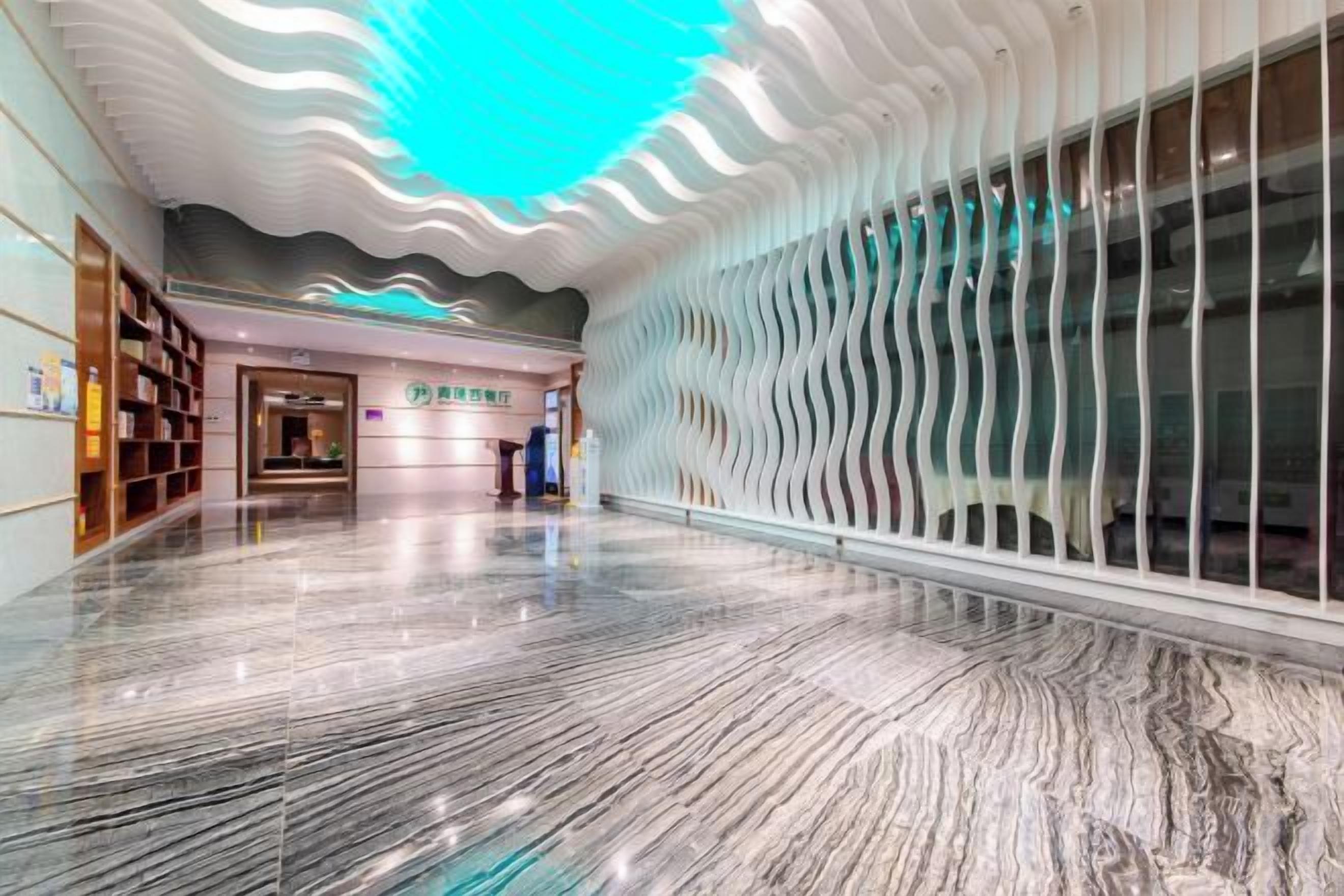 A spacious lobby with a marble floor, a modern ceiling design, and a reception area.
