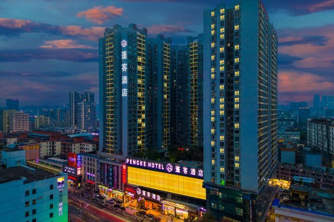 A high-rise hotel with multiple floors, a prominent hotel sign, and a cityscape in the background.