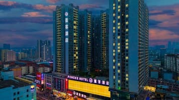 A high-rise hotel with multiple floors, a prominent hotel sign, and a cityscape in the background.