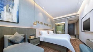 A modern hotel room with a large bed, a seating area, a flat-screen TV, and a wall-mounted artwork. - Pengke Hotel (Shenzhen North Railway Station Shangmu) (Shenzhen)