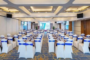 A conference room with rows of white chairs, blue sashes, and a carpeted floor. - Pengke Hotel (Shenzhen North Railway Station Shangmu) (Shenzhen)