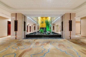 A spacious lobby with a central fountain, a patterned floor, and a high ceiling. - Pengke Hotel (Shenzhen North Railway Station Shangmu) (Shenzhen)