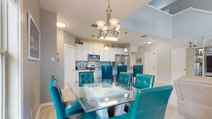 A modern kitchen with white cabinets, a microwave, and a refrigerator. - Shared Pool, Pet Friendly, Golf Cart Access (Port Aransas)