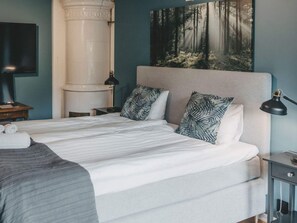 A neatly made bed with a white comforter and two patterned pillows, a bedside lamp, and a wall-mounted flat-screen TV. - 4 Star Holiday Home in Hisings Backa (Hisings Backa)