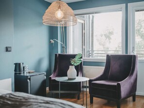 A room with a bed, a table with a vase and plant, two chairs, a lamp, and a window with a view. - 4 Star Holiday Home in Hisings Backa (Hisings Backa)