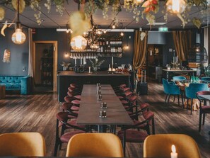 A restaurant with a long wooden table, red chairs, and a bar area with shelves of bottles. - 4 Star Holiday Home in Hisings Backa (Hisings Backa)