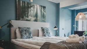 A bedroom with a bed, pillows, a headboard, bedside lamps, a hanging light fixture, and a painting on the wall. - 4 Star Holiday Home in Hisings Backa (Hisings Backa)