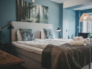 A bedroom with a bed, pillows, a headboard, bedside lamps, a hanging light fixture, and a painting on the wall. - 4 Star Holiday Home in Hisings Backa (Hisings Backa)
