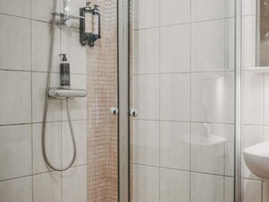 A shower area with a glass door, a handheld showerhead, and a wall-mounted soap dispenser. - 4 Star Holiday Home in Hisings Backa (Hisings Backa)