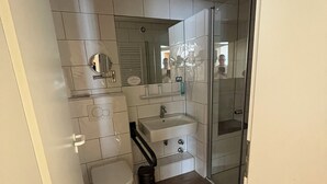 Ein modernes Badezimmer mit Toilette, Waschbecken und Dusche.