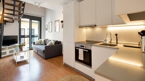 A modern kitchen with white cabinets, a built-in oven, and a stainless steel sink. - Happy Travel Churruca 25 (Málaga)