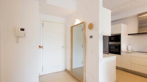 Une cuisine moderne avec des meubles blancs, un four encastré et un four à micro-ondes.