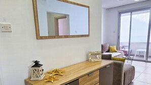 A modern kitchen with a wooden countertop, a built-in dishwasher, and a large mirror above it. - Seaside Comfort Residence (Larnaca)