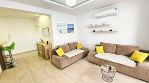 Apartamento, vista para a cidade | Área de estar | TV de tela plana