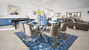 A modern dining area with a glass table, four chairs, and blue and gold accents. - Beautiful 4BD/2BA Hilltop Oasis (Phoenix)