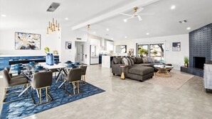 A spacious living area with a dining table, sofas, and a fireplace. - Beautiful 4BD/2BA Hilltop Oasis (Phoenix)