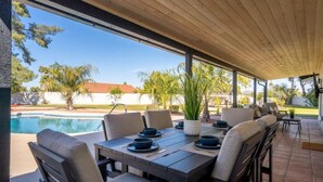 An outdoor patio with a pool, dining table set with plates and bowls, and chairs. - Beautiful 4BD/2BA Hilltop Oasis (Phoenix)