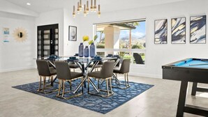 A modern dining area with a glass table, dark chairs, and a blue patterned rug. - Beautiful 4BD/2BA Hilltop Oasis (Phoenix)