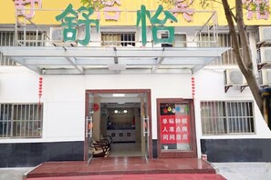 A building entrance with a signboard and a staircase leading to the entrance. - Shuyi Hotel (Binhai)