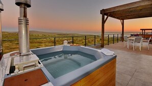 A hot tub with a view of the horizon, a wooden deck, and outdoor furniture. - The Shark Bay Private Villas (Langebaan)