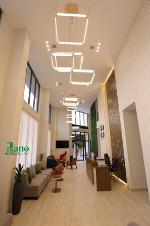 A hotel lobby with a reception desk, seating area, and modern lighting fixtures. - Jano hotel (Addis Ababa)