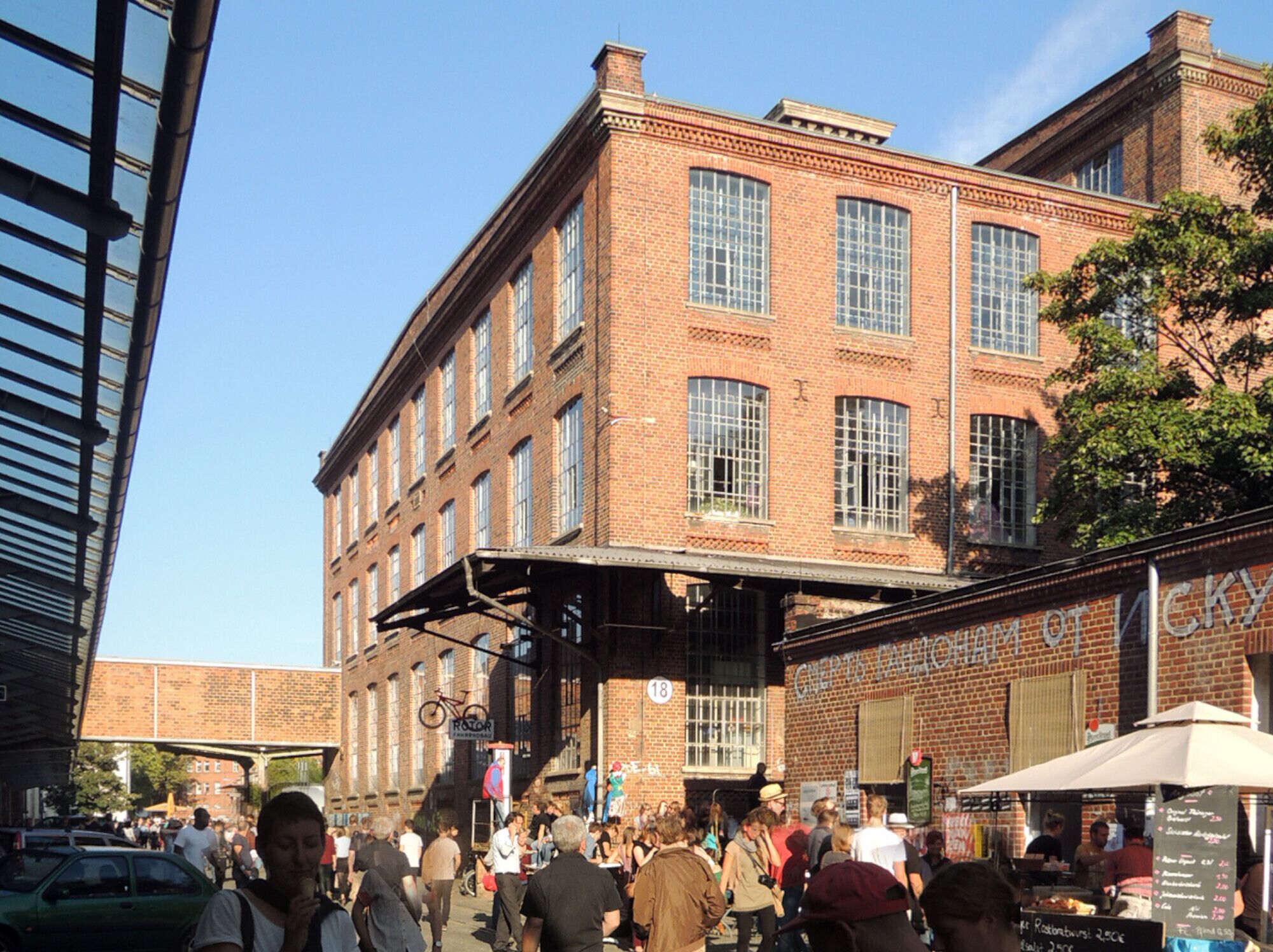 A historic brick building with large windows and a covered outdoor area.