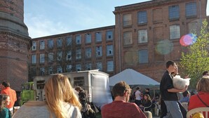Un espacio al aire libre con mobiliario y edificios de ladrillo al fondo.