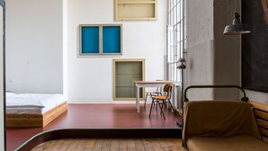 Una habitación pequeña con una cama, una mesita y una silla.