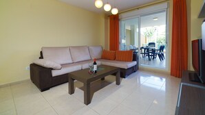 Een woonkamer met een bank, een salontafel en een televisie.