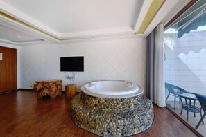 A modern bathroom with a stone tub, wooden furniture, and a large window.