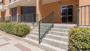 A building entrance with a staircase, a glass door, and a metal gate.