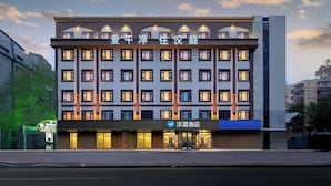 Un hotel de diverses plantes amb façana moderna, que destaca per una sèrie de balcons i una señalització visible que indica que és un hotel.