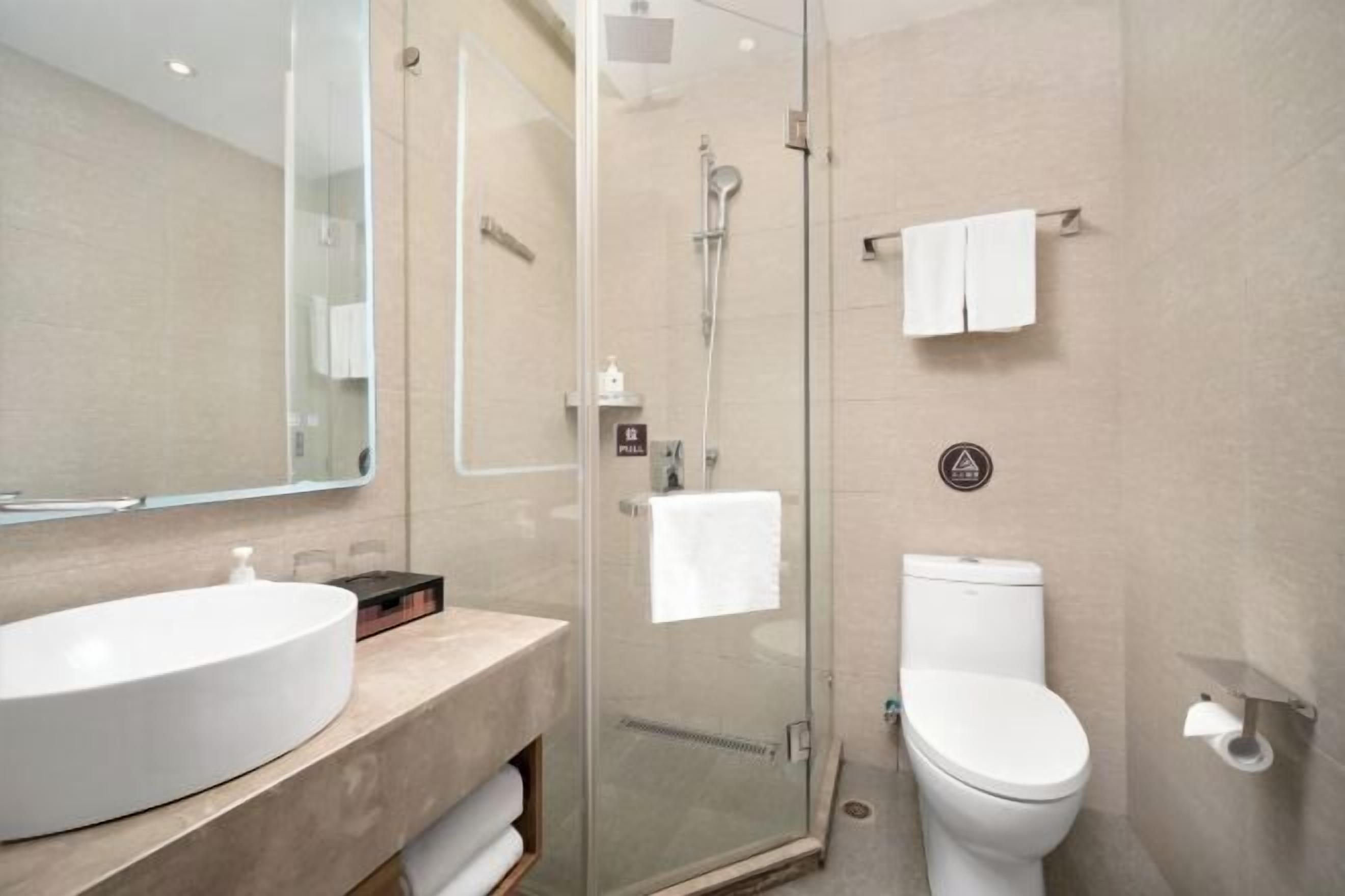Un bagno moderno con doccia vetrata, un lavandino bianco e un water.
